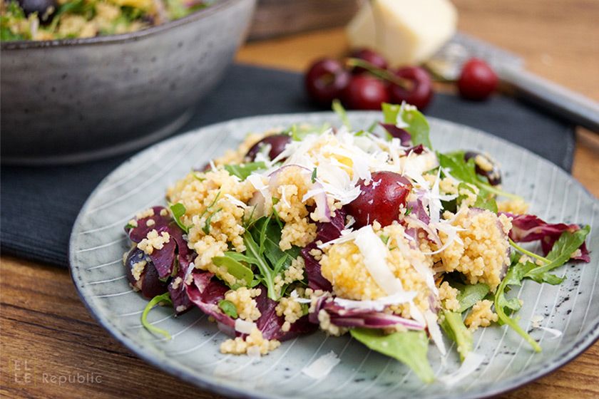 Rezeptbild: Mit Orangensaft versetztes Couscous mit Kirschen auf Rucola