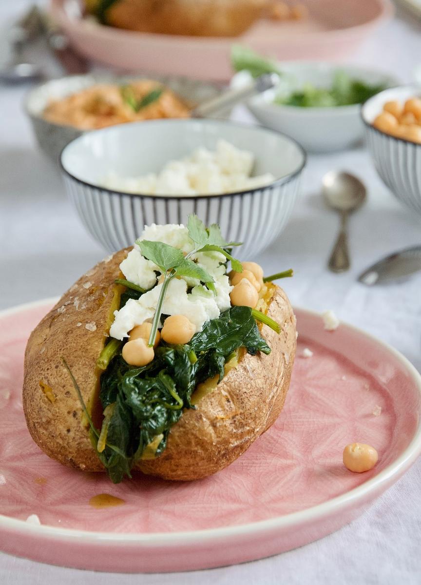 Rezeptbild: Gefüllte Ofenkartoffeln mit Harissa-Hummus, Kurkuma-Spinat, Kichererbsen und Feta