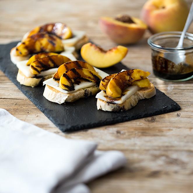 Rezeptbild: Bruschetta mir gegrilltem Pfirsich, Ziegenkäse und Balsamico-Sirup