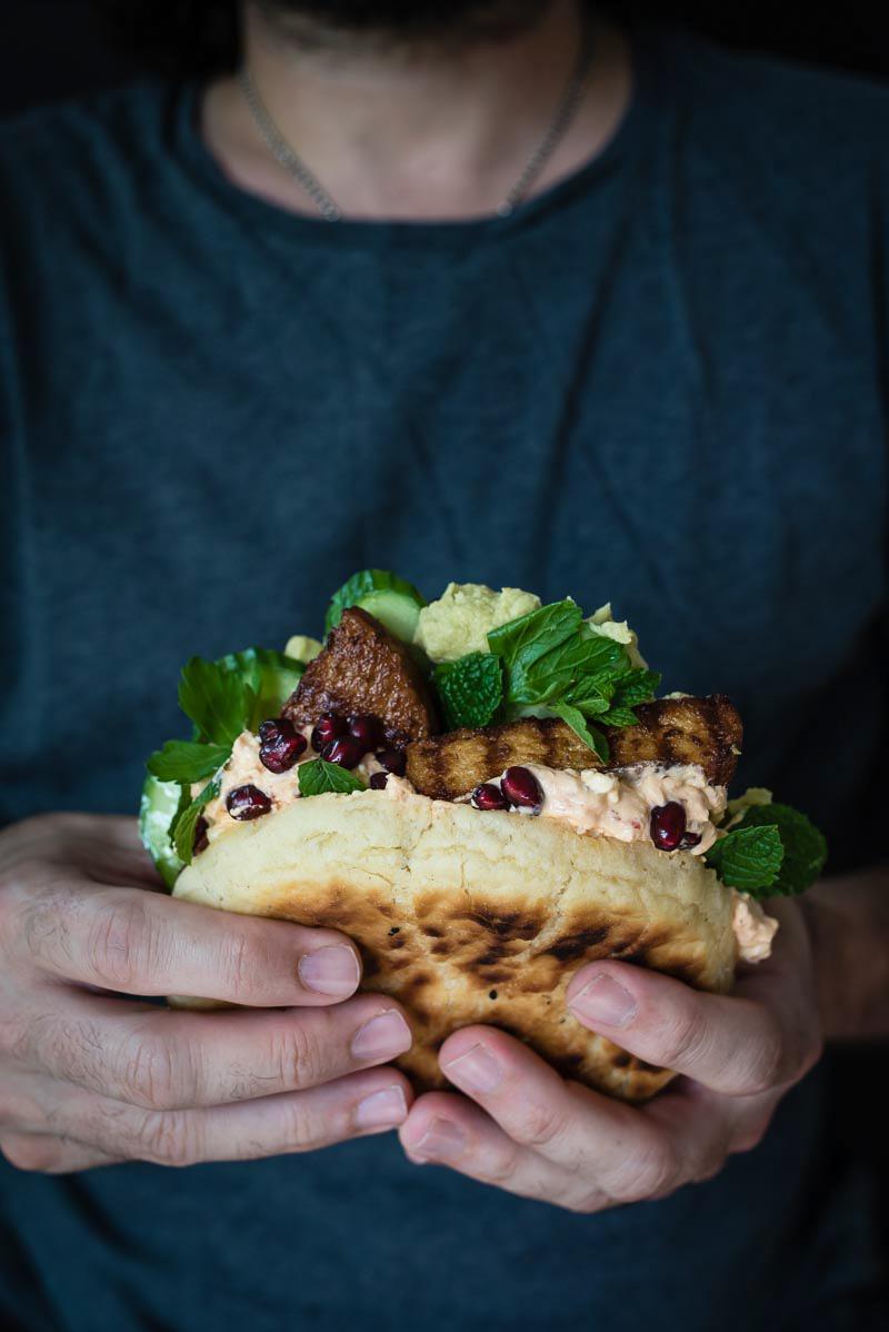 Rezeptbild: Pfannen Pita Brot, gefüllt mit Veggie Frikadellen, Avocadohummus, Harissajoghurt, Gurken und Granatapfel