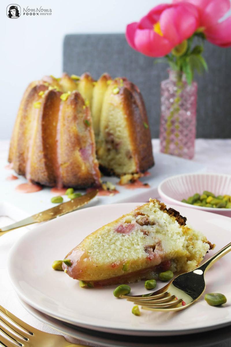 Rezeptbild: Fluffiger saftiger Rhabarber-Rührkuchen mit Erdbeer-Glasur und Pistazien