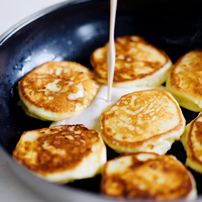 Rezeptbild: Quarkpuffer mit Saurer Sahne und Ahornsirup - Syrniki