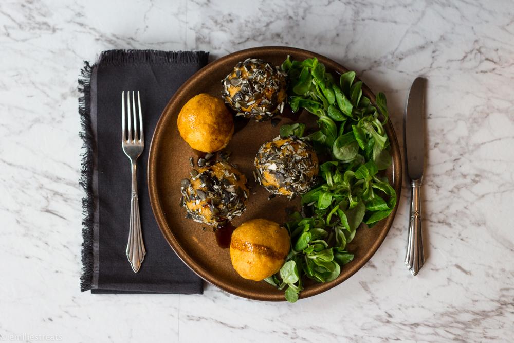 Rezeptbild: Knallige Kürbisknödel in kerniger Kruste an Feldsalat