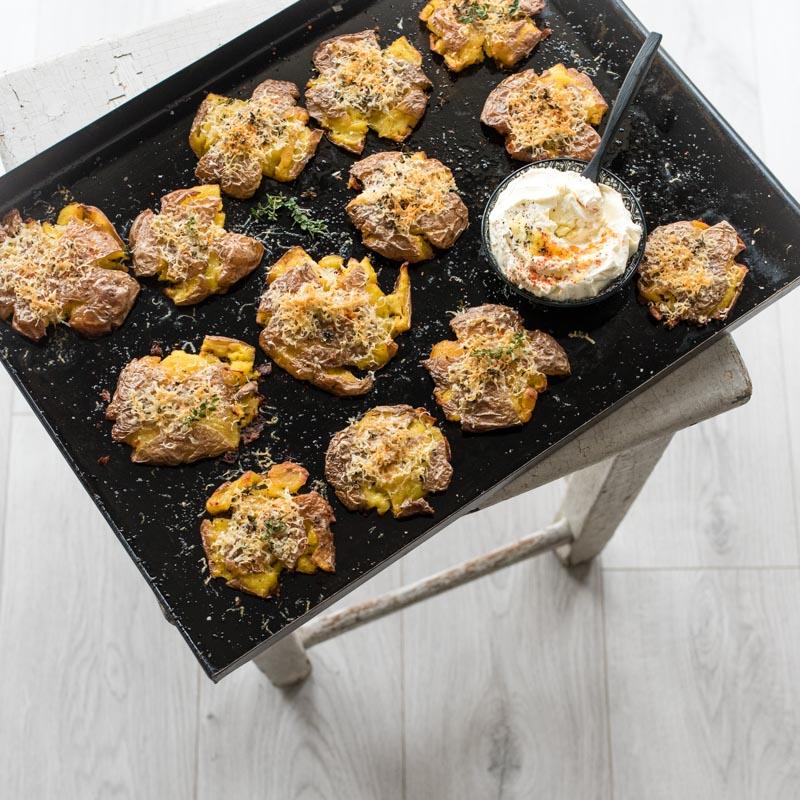 Rezeptbild: Knusprige Quetschkartoffeln mit Parmesan Thymian Kruste und einem Knoblauch Créme Fraiche Dip