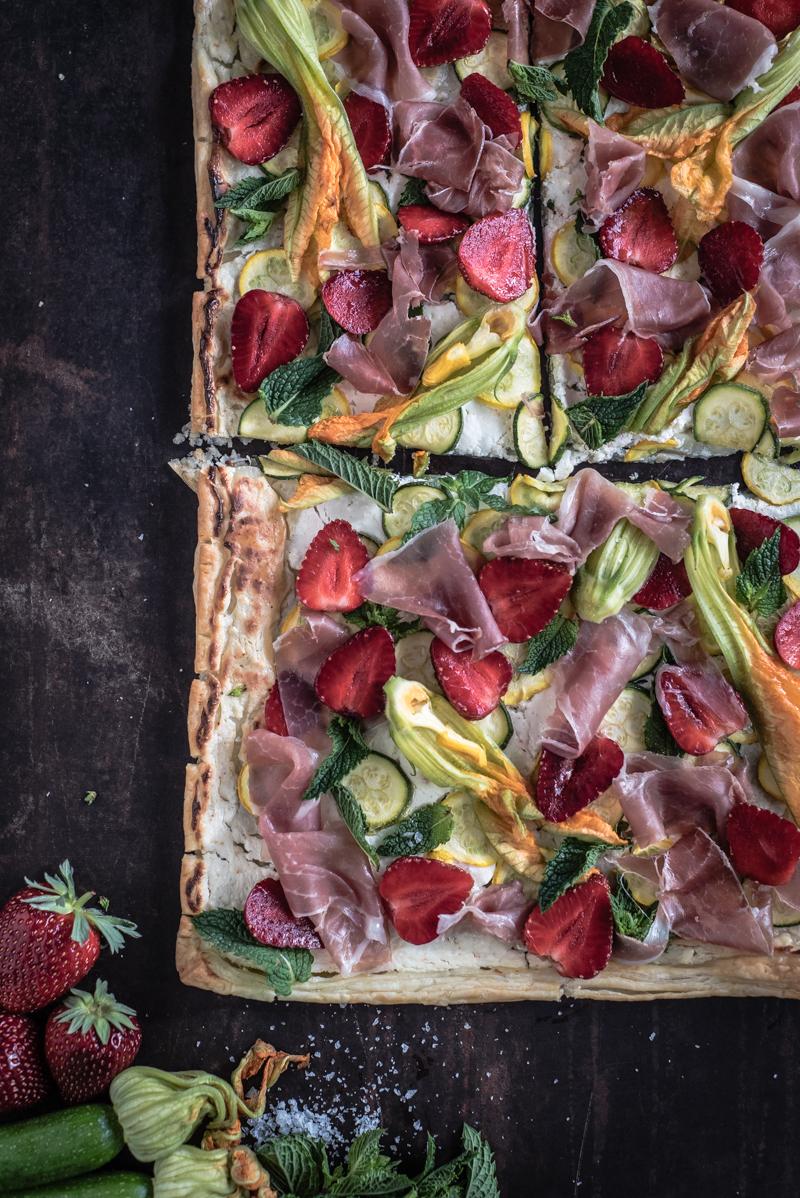 Rezeptbild: sommerlicher flammkuchen mit zucchini, erdbeeren, parmaschinken, ziegenfrischkäse und minze