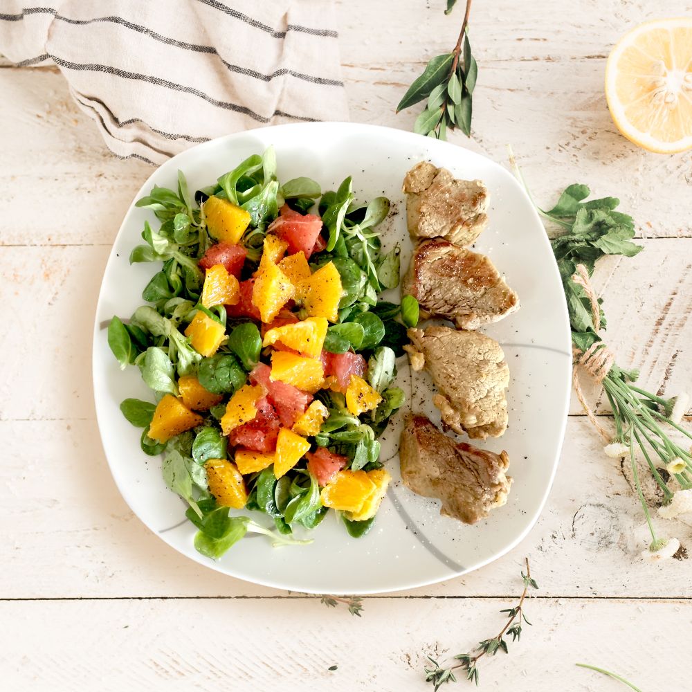 Rezeptbild: Fruchtiger Salat mit Schweinemedaillons
