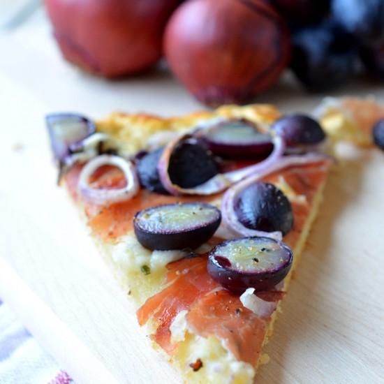 Rezeptbild: Pizza mit Kräuterquark, roten Zwiebeln, Trauben und Speck