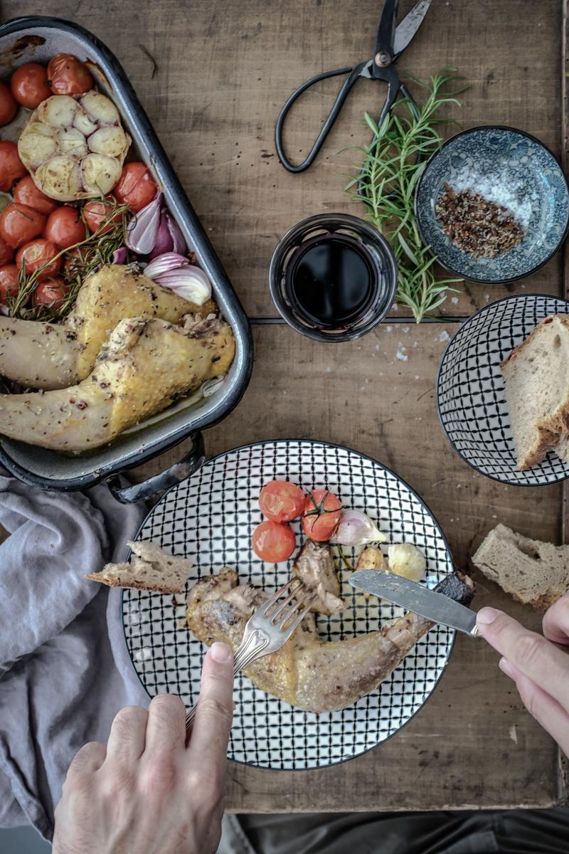 Rezeptbild: mediterrane perlhuhnkeulen, gerösteter knoblauch und confierte tomaten aus dem ofen