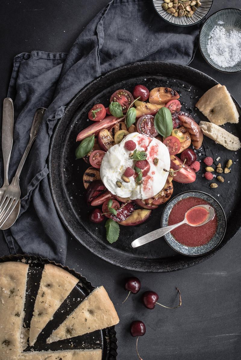 Rezeptbild: gegrillte kernobst caprese mit burrata, himbeervinaigrette, gerösteten pistazien und rosmarin focaccia 