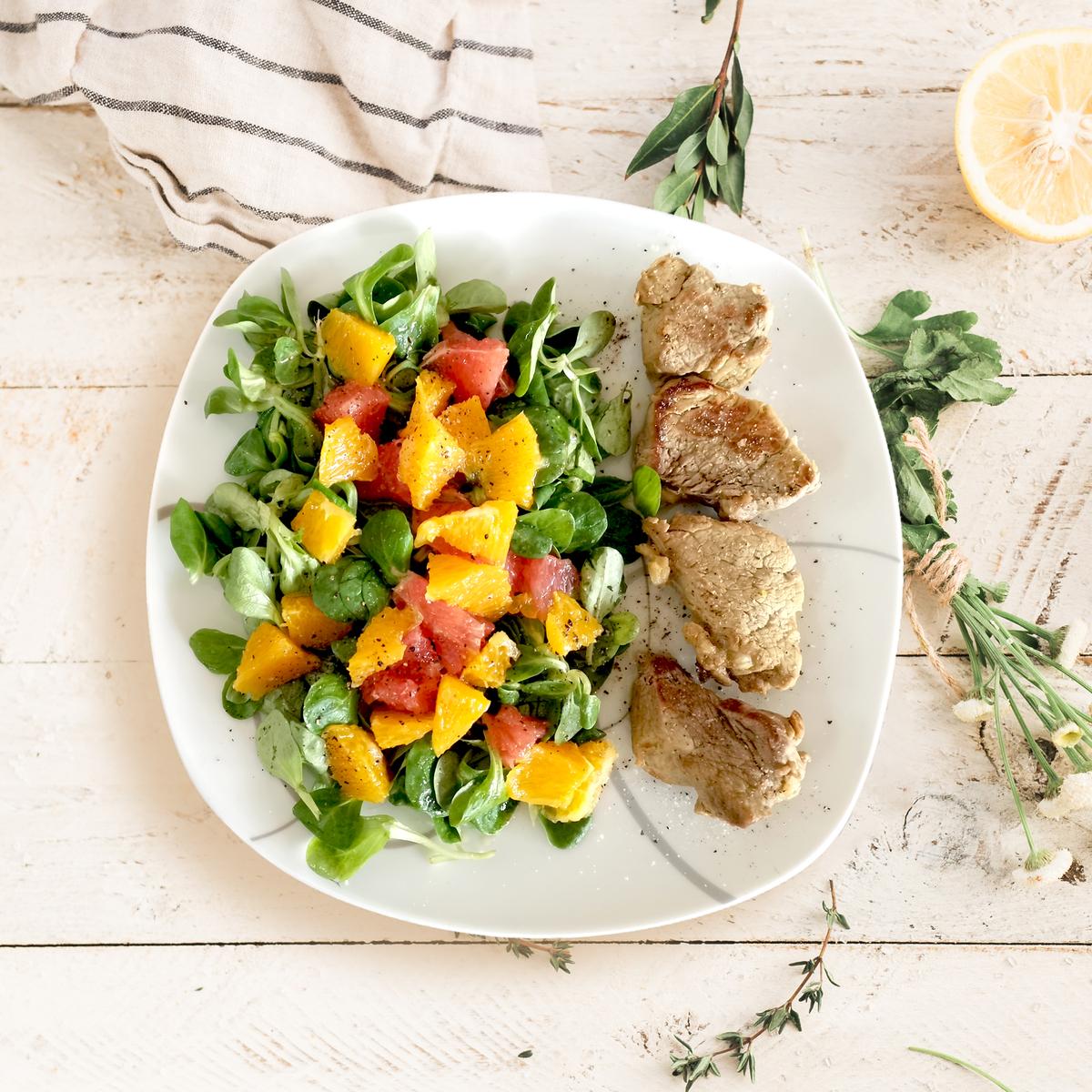 Rezeptbild: Fruchtiger Salat mit Schweinemedaillons