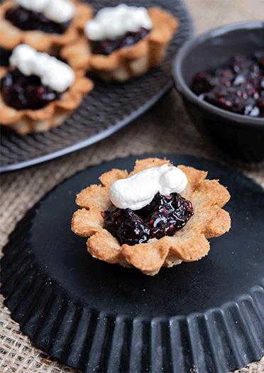 Rezeptbild: Mandelmuscheln mit Glögg-Beeren und Zimtsahne