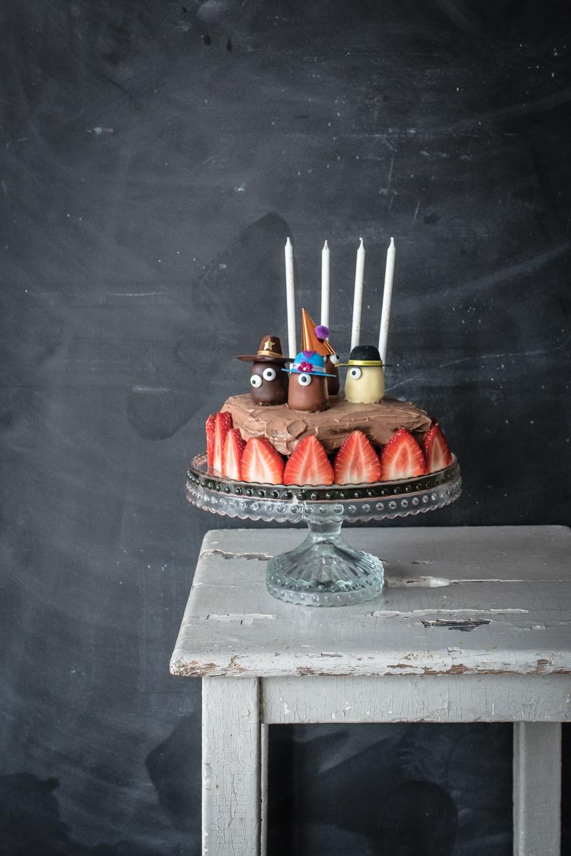 Rezeptbild: saftiger schokobrowniekuchen mit schokofrischkäsefrosting und der legendären schokokuss partyhütchencrew
