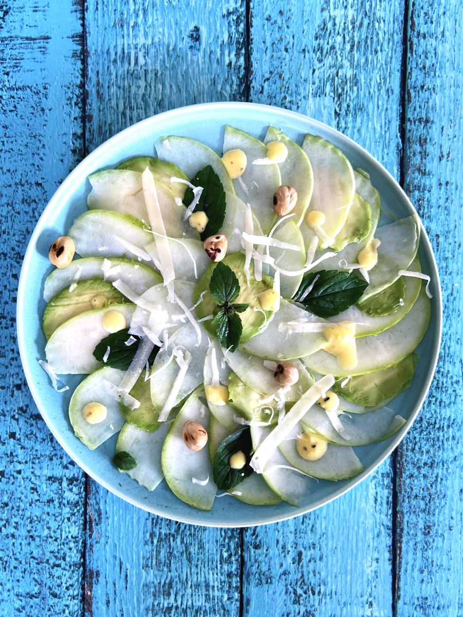 Rezeptbild: Kohlrabi Carpaccio mit Avocado, Parmesandressing und grösteten Haselnüssen