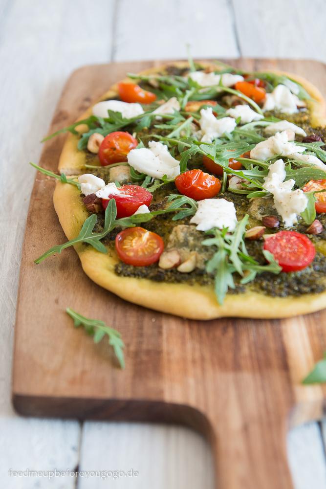 Rezeptbild: Bärlauch-Pizza mit Tomaten, Burrata, Rucola & Haselnüssen