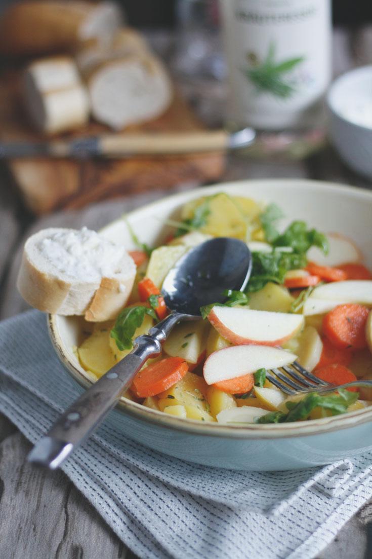 Rezeptbild: Kartoffelsalat mit Apfel, Granatapfel, Karotten, Pastinaken und Rucola. 