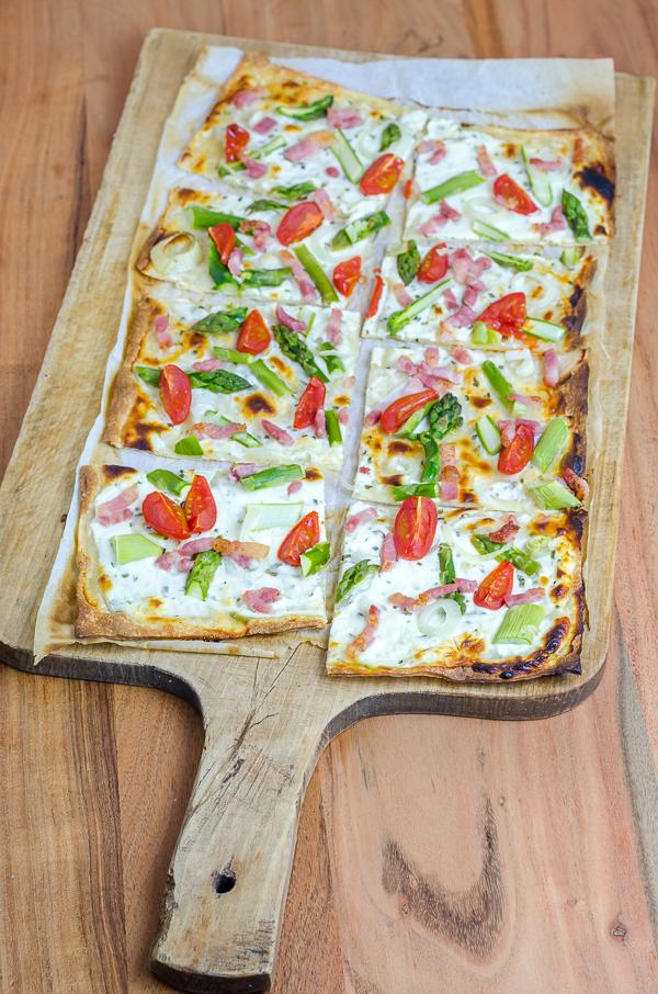 Rezeptbild: grüner Spargel Flammkuchen mit Speckstreifen und Cherry Tomaten 