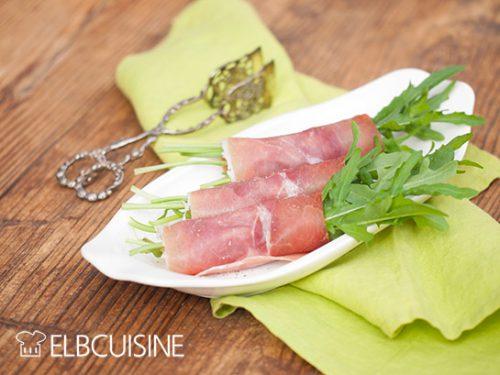 Rezeptbild: Verlockende Rucola-Serrano-Röllchen gefüllt mit mariniertem Mozzarella